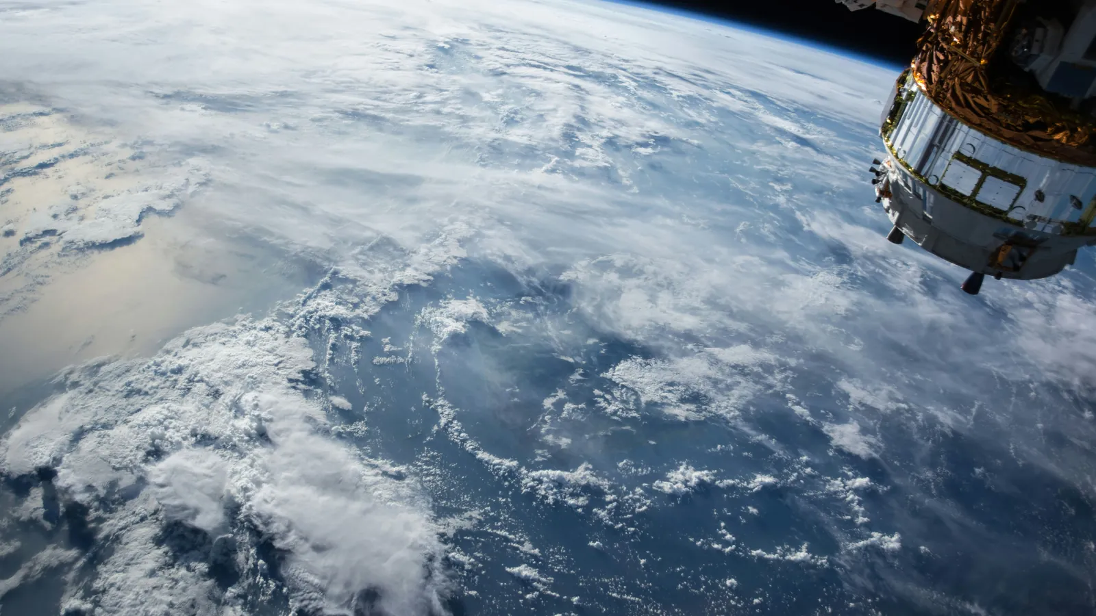 Earth's curved horizon and a swirling storm system seen from orbit.