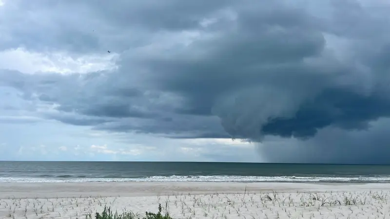 A dark shelf cloud from an advancing squall line spreading over the sea.